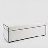 Ivory upholstered storage ottoman with blue piping detail and hidden compartment for luxury bedroom furniture