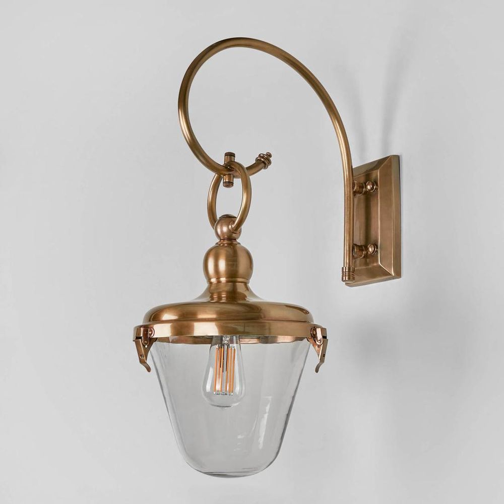 Savoy Outdoor Wall Light in antique brass with curved arm and glass shade – elegant outdoor wall sconce for patios, verandas, balconies, and entryways