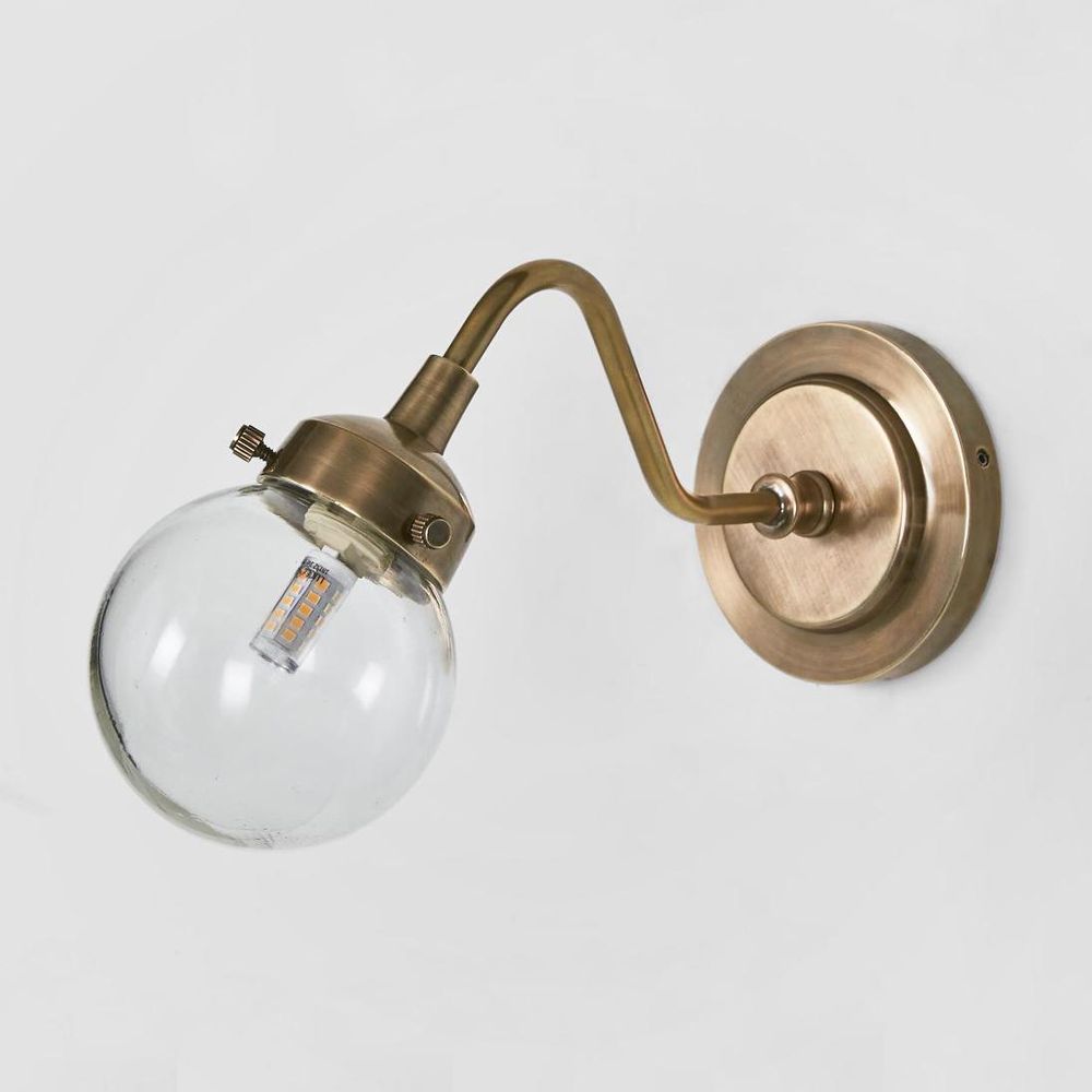 Beacon Outdoor Wall Light antique brass with curved arm and glass globe – elegant adjustable outdoor wall sconce for entryways, patios, and modern exteriors