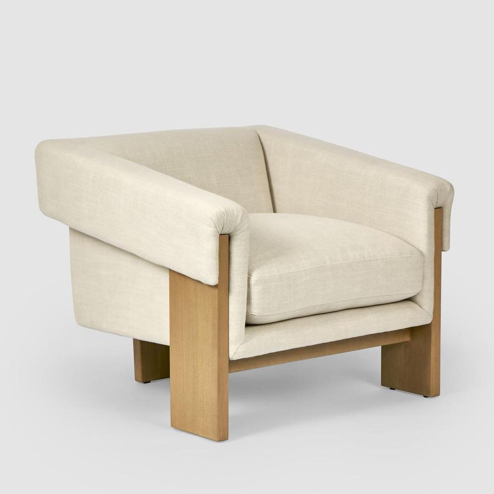 Claude armchair vintage-inspired accent chair with wide plank legs and upholstered seat in modern living room