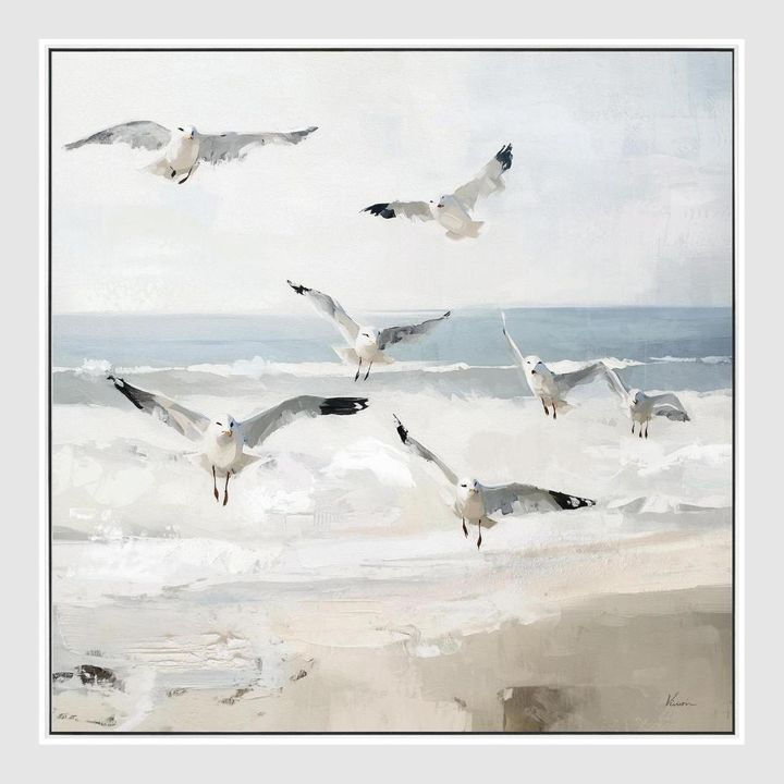 Seaside Flight canvas artwork of seagulls soaring above gentle coastal waves in soft whites, sandy creams, and sea blues.