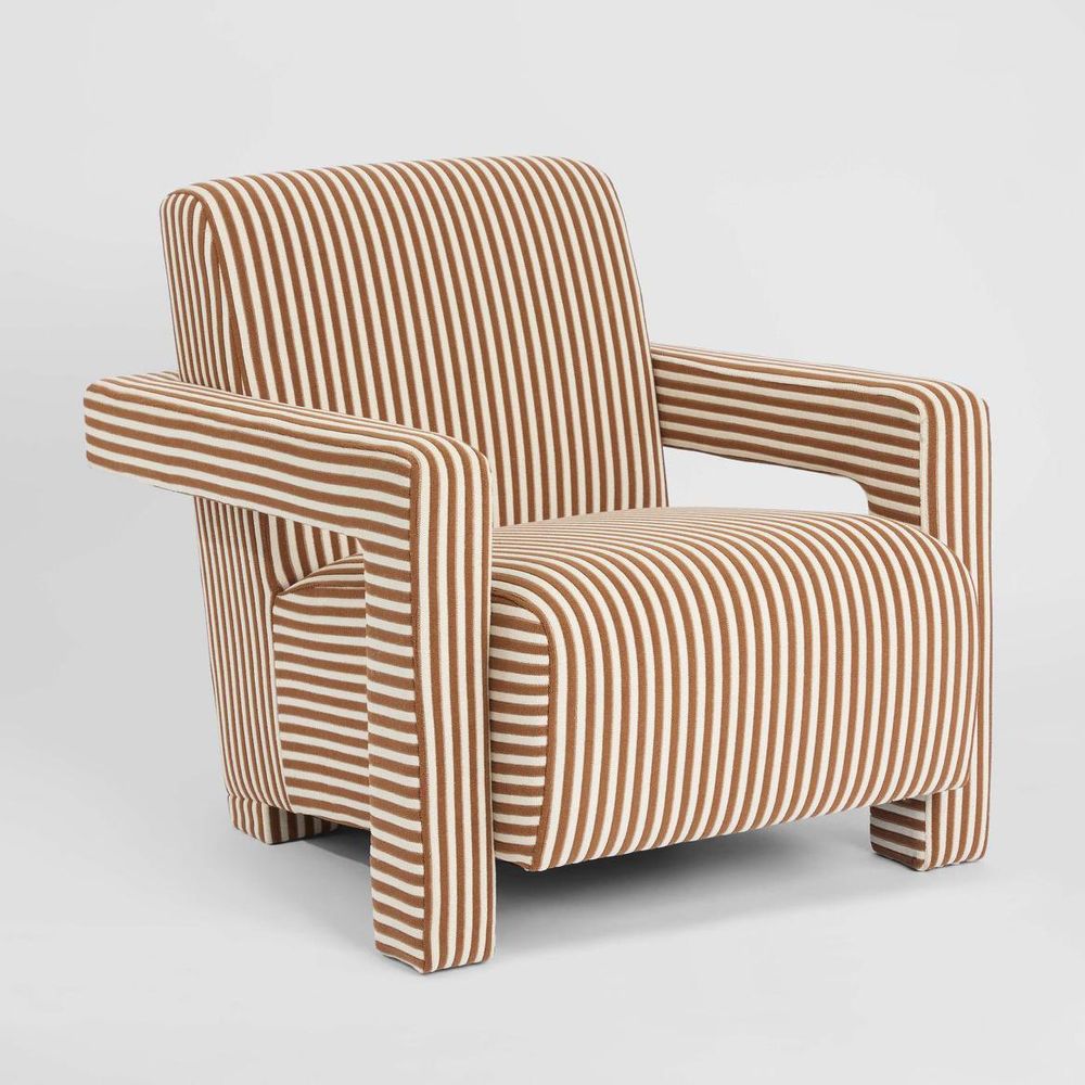 Art Deco inspired upholstered armchair with structured arms and sculptural silhouette for modern interiors
