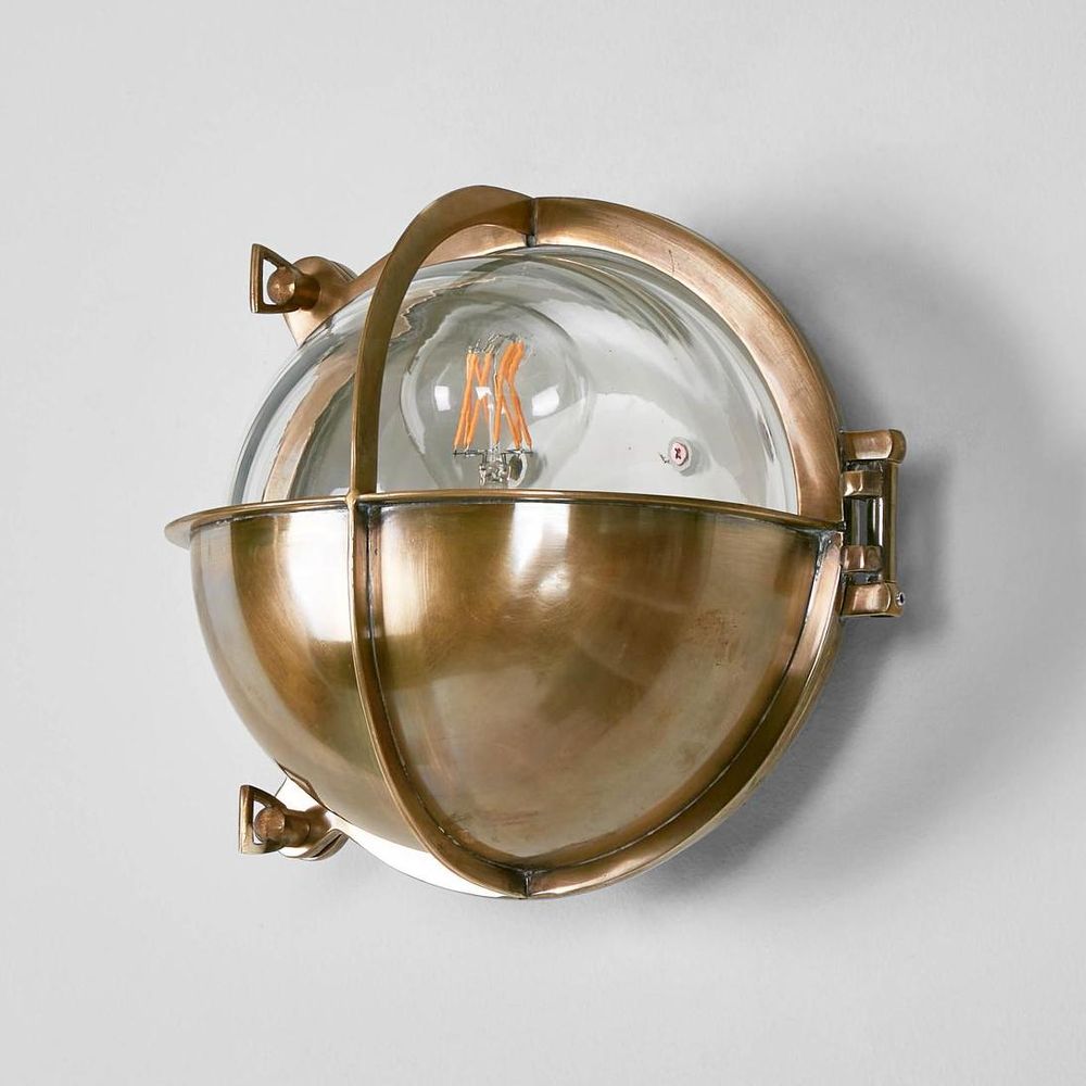 Vienna Outdoor Wall Lamp in antique brass with half-round cover and clear glass – nautical brass wall light for coastal homes, patios, and bathrooms